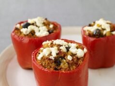 Colorful Foxtail Millet Stuffed Bell Peppers with melted cheese on top, garnished with fresh herbs.