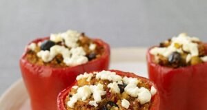 Colorful Foxtail Millet Stuffed Bell Peppers with melted cheese on top, garnished with fresh herbs.