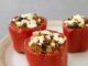 Colorful Foxtail Millet Stuffed Bell Peppers with melted cheese on top, garnished with fresh herbs.